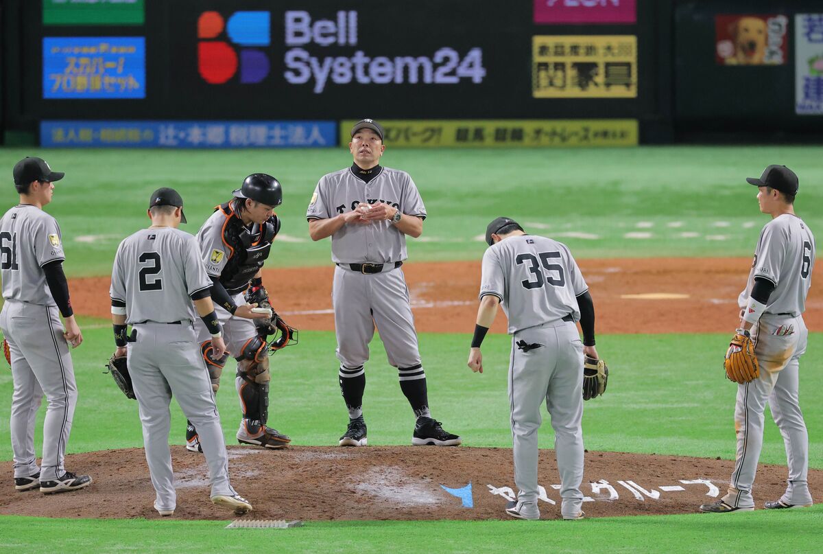５回途中、選手交代を告げた阿部監督（中）（カメラ・朝田　秀司）